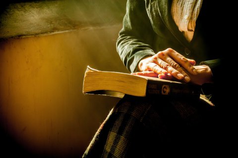 Frau mit Buch auf dem Schoß